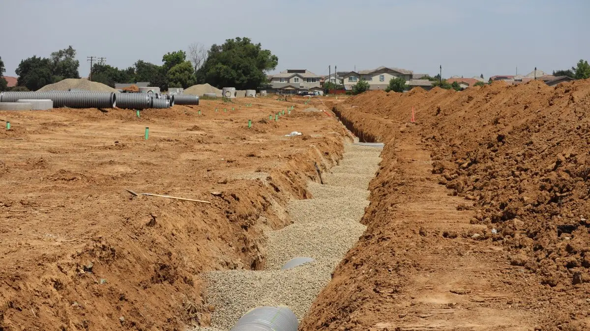 Drainage trench with gravel and corrugated pipe during a residential drainage installation